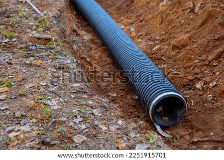 Laying for underground installation of PVC sewage black pipes in ground is prevent subterranean flooding.