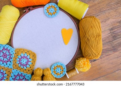 Layout Of Balls Of Yarn, Embroidery Hoop With Blank Tightened Fabric, Crochet Patterns, Spools Of Thread On Wooden Surface. Concept Of Love For Hand Made And Crafts.