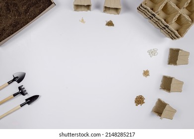 Layout of garden tools and seeds for planting on a white background.Earth,pots for seedlings, shovels.The concept of gardening, agriculture, preparation for planting seeds.Copy space.High quality phot