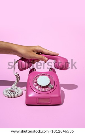 Layout made of pink telephone on blue background. Retro vintage 60's and 70's aesthetic with summer shadows. Flat lay.