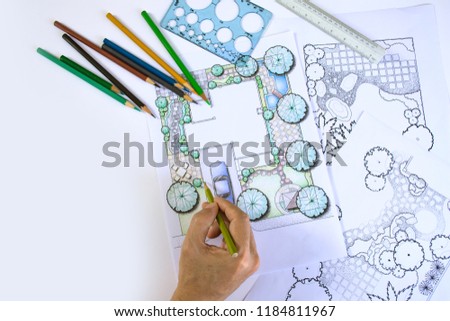 layout plan of home landscape design or garden design or landscape architecture drawing by hand with color pencil on white paper with drawing tools and group of color pencils, selective focus