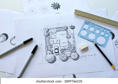 layout plan of  landscape design or garden design or landscape architecture, rough sketching with black pen, pencil, circle template ruler, scale ruler and other tools on white paper, selective focus