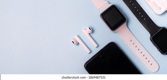 The layout of the watch and the phone on a blue background. Appliances and electronics. Modern gadgets. Phone headphones watch. Business. Wireless headphone. Watch with pedometer. - Shutterstock ID 1869487531