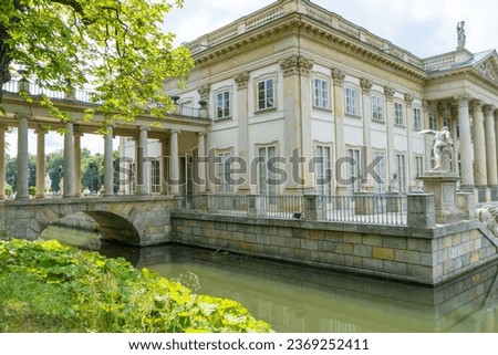 Lazienki Park with pond. Polish Lazienkowski or Lazienki Krolewskie is the polish park. Lake house with pond. The palace on the water is a monument of architecture.
