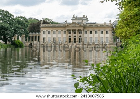 Lazienki Park with pond. Polish Lazienkowski or Lazienki Krolewskie is the polish park. Lake house with pond. The palace on the water is a monument of architecture.