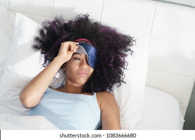 Lazy Black Girl With Blindfold In Bed Late In The Morning. Tired African American Woman With Sleeping Mask Sleeping During Daytime.