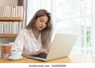 Lazy bored asian woman using laptop in the morning. - Shutterstock ID 1669058209