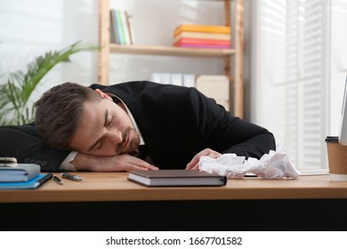 Lazy employee sleeping at table in office - Shutterstock ID 1667701582