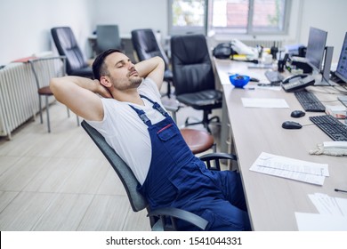 Lazy Factory Worker Sitting On Chair With Hands Behind Head And Sleeping In Control Room.