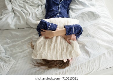 Too lazy to get out of bed, a woman covers her face with a pillow - Shutterstock ID 710815021
