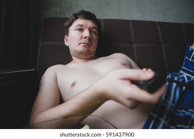 Lazy Man With Beer And Chips Watching TV At Home