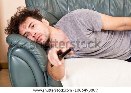 Lazy man with the remote on the couch