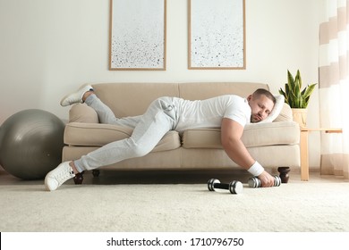 Lazy Overweight Man With Dumbbells Sleeping On Sofa At Home