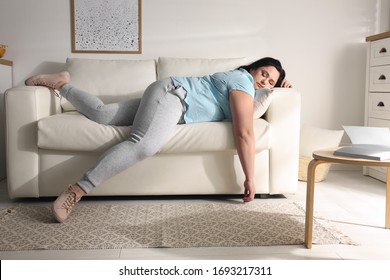 Lazy overweight woman resting on sofa at home