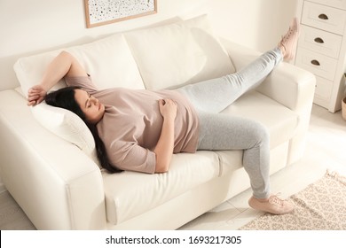 Lazy overweight woman sleeping on sofa at home