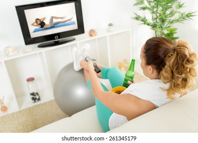 Lazy Woman In Sport Clothing Sitting Front Of The TV And Doesn't Wont To Exercise.