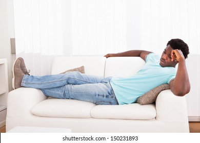 Lazy Worried African Young Man Sitting On Couch At Home