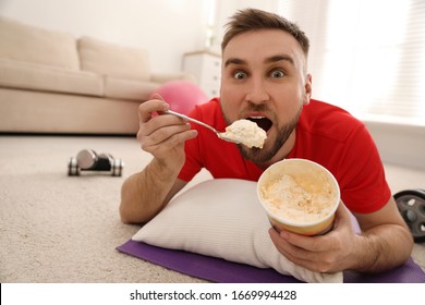 Lazy Young Man Eating Ice Cream Instead Of Training At Home