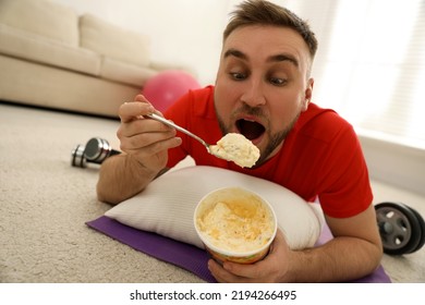 Lazy Young Man Eating Ice Cream Instead Of Training At Home