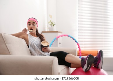 Lazy Young Woman Eating Ice Cream Instead Of Training At Home