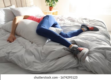 Lazy young woman sleeping on bed instead of morning training - Powered by Shutterstock