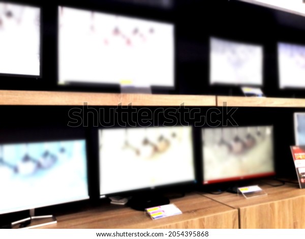 LCD screens of various sizes are\
displayed on the counter. Blurred paragraph with background and\
design elements. Bokeh lights defocused\
background.