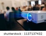 LCD video projector at business conference or lecture in office with copy space. projector on ceiling indoors.