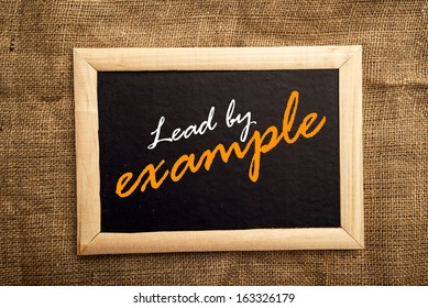 Lead by example note on black message board