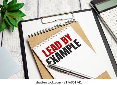 lead by example, text on white paper on the light background with charts paper