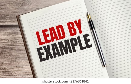 lead by example text on a notepad with pen, business