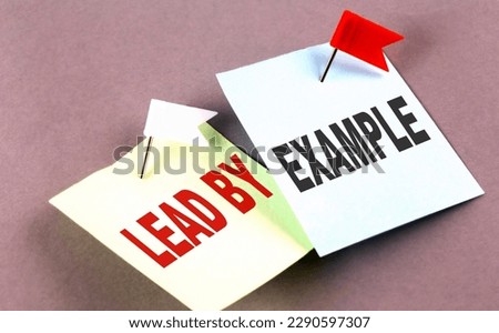 LEAD BY EXAMPLE text on sticky on grey background
