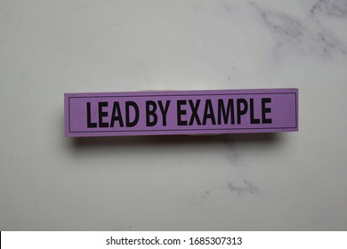 Lead by Example write on sticky note isolated on Office Desk