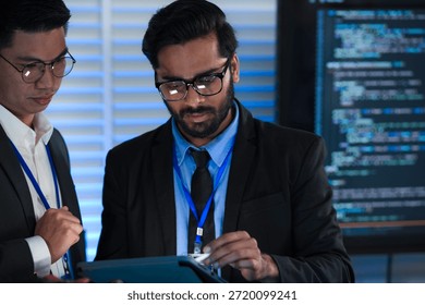 Lead developers analyze system architecture late night using tablet stylus pointing out details colleagues focused code visible screens debugging technical deep dive software build.
