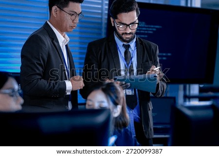 Lead developers analyze system architecture late night using tablet stylus pointing out details colleagues focused code visible screens debugging technical deep dive software build.