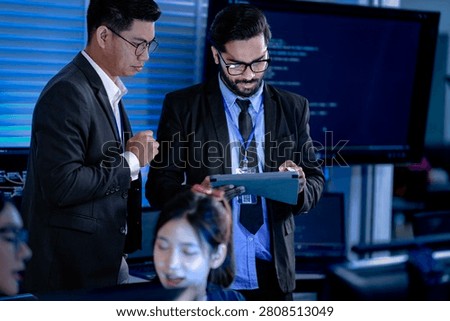 Lead developers analyze system architecture late night using tablet stylus pointing out details colleagues focused code visible screens debugging technical deep dive software build.