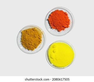 Lead (II,IV) Oxide, Potassium Chromate And Organic Curcuma Powder In Chemical Watch Glass. Closeup Chemical Ingredient On White Laboratory Table. Top View