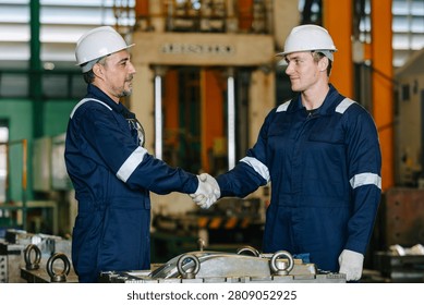 Lead senior engineer worker hand shaking with young man for deal success or agree project job in die casting plant