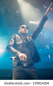 Lead singer of music group performs on stage with spotlights