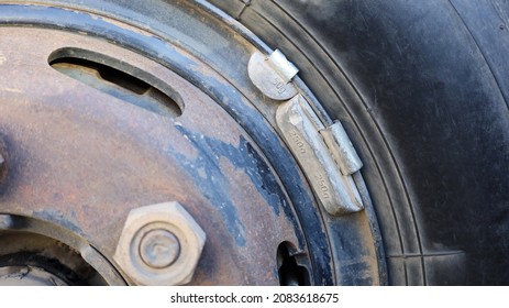 Lead weight on black car rims.  Lead-weighted wheel balancing for vehicle wheel balance while in use with copy space. Focus close and choose the subject. - Shutterstock ID 2083618675