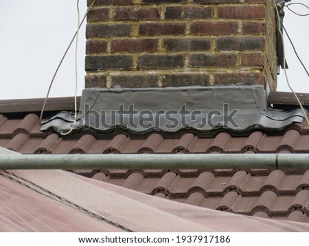 Lead work at the base of a brick chimney stack