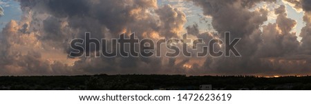 Leaden, storm clouds covered the sunset. Cumuliform cloudscape on blue sky. The terrain in southern Europe. Fantastic skies on the planet earth. Tragic gloomy sky.	