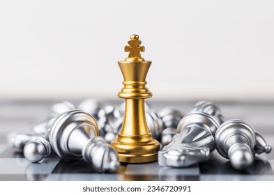 Leader, business strategy and planning concept, Gold Chess king figure on Chessboard and surrounded by a number of fallen silver chess pieces against opponent or enemy. Conflict, tactic, politic.
