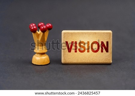 Leader concept. On a black surface there is a chess piece and a wooden block with the inscription - Vision