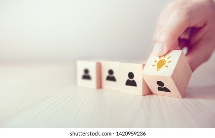 Leader with idea and innovation, Woman hand flips cube with icon light bulb and human symbol. - Shutterstock ID 1420959236