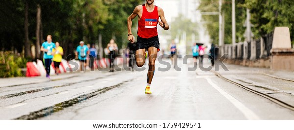 leader marathon race athlete runner run in rain on\
city street
