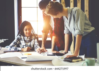 Leaders of working team consulting young trainee in projecting interior design developing concept of planning, skilled male and female students checking accountings for sketch creation together - Shutterstock ID 644271997