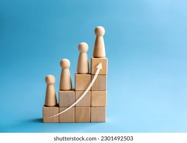 Leadership with business success concept. Modern rising up arrow and wooden figures standing on a growth graph chart steps arranged by wood cube blocks isolated on blue background with copy space. - Shutterstock ID 2301492503