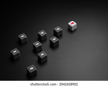 Leadership Concept, Manager, CEO, Influencer, Opinion Leader, And Business Leading. The Leader With Red Arrow On White Dice Leading The Black Dice Group With White Arrow, Followers On Dark Background.