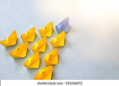 Leadership concept with paper boats on blue wooden background. One leader ship leads other ships. Filtered and toned image - Shutterstock ID 551036872