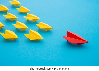 Leadership concept. Red paper plane origami leading among small yellow planes on blue background. Leadership skills need for top management in organization, company such as supervisor, manager, CEO